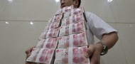 An employee carries bundles of 100 yuan Chinese bank notes after counting at a bank in Taiyuan